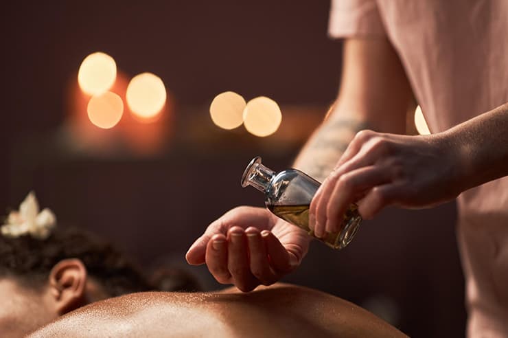 A woman pouring massage oils into her hands