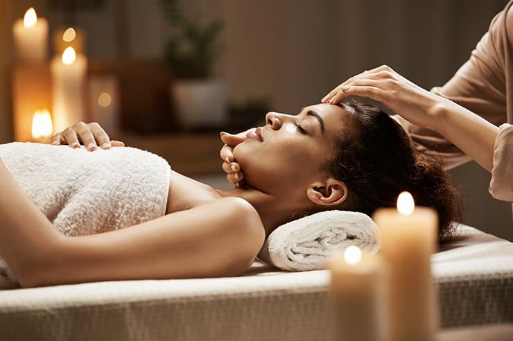 A woman getting a massage with candles lit all around her